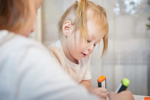 Cute little sisters are painting on table. Preschooler, 4 and 8 years child in living room. Small girl kids doing homework, home schooling concept