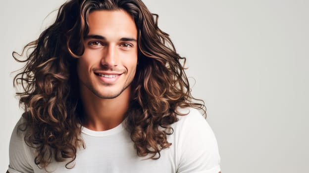 Portrait of an elegant sexy smiling Latino man with perfect skin and long hair, on a white background. Advertising of cosmetic products, spa treatments shampoos and hair care products, dentistry and medicine, perfumes and cosmetology for men