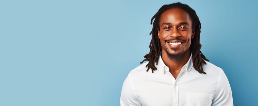 Portrait elegant sexy smiling African man with dark and perfect skin and long hair, on a light blue background. Advertising of cosmetic products, spa treatments shampoos and hair care products, dentistry and medicine, perfumes and cosmetology for men