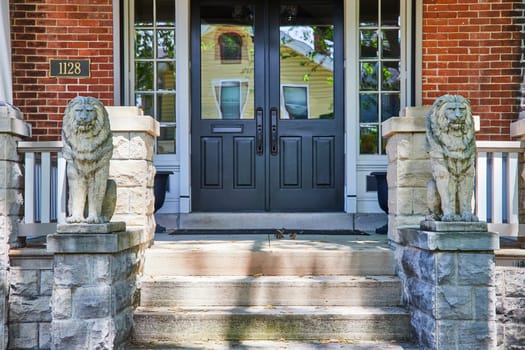 Elegant Fort Wayne home entrance with lion statues and lush greenery, symbolizing security and luxury.