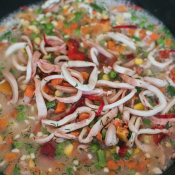 Squid rings with vegetables are cooked in a pan for a delicious dinner