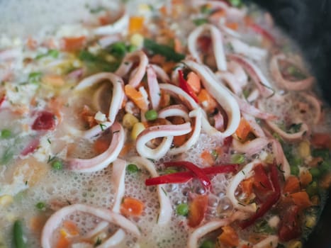 Squid rings with vegetables stewed in a pan