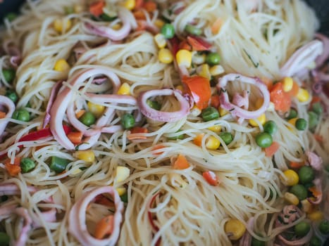spaghetti with squid and vegetables close-up