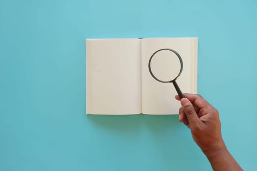 open book and magnifying glass on table