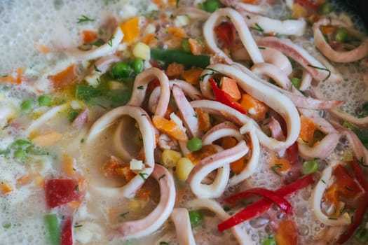 Squid rings with vegetables stewed in a pan