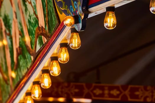 Vintage-inspired cafe ambiance with artistic mural and warm filament bulbs, enhancing a cozy, bohemian setting.