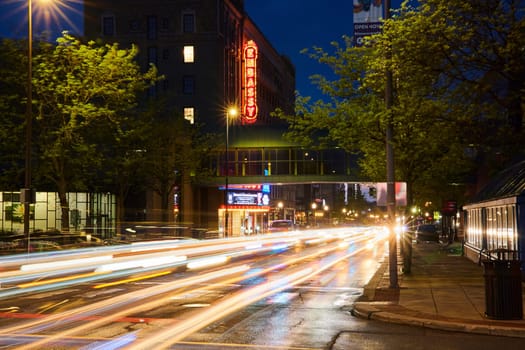 Dynamic blue hour in downtown Fort Wayne: vivid city lights, bustling streets, and the iconic Embassy Theatre.