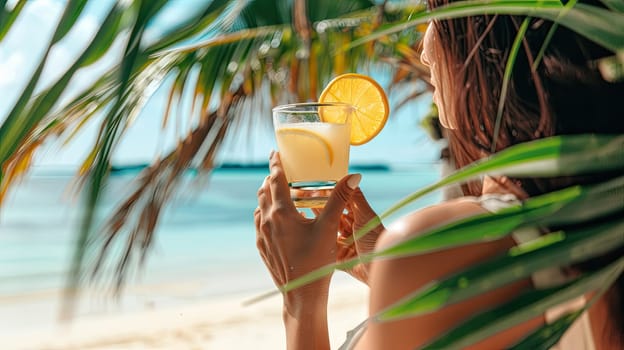 A cocktail in the hands of a girl on the beach. Selective focus. Drink.