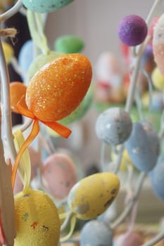 easter concept with multi color egg hanging on a decorative tree .