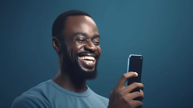 A happy stylish african-american man watches a smartphone in his hands, on a dark blue background. Close up. Copy space