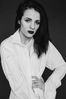 fashion portrait of attractive brunette girl posing in white shirt. Black and white with added noise