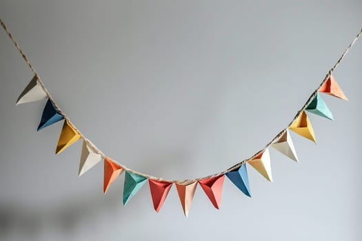 Colorful holiday flags in the form of a garland on the wall. The garland hangs in one row. Congratulatory background with place for text.