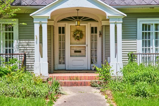 Charming seafoam green home with a welcoming porch in the South Wayne Historic District.