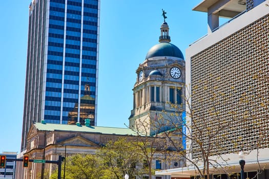 Historic Allen County Courthouse meets modern skyscrapers under clear skies in Fort Wayne.