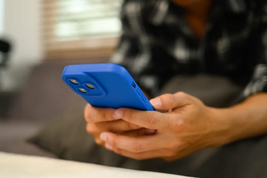 Closeup image of man reading text message and chatting in mobile application.