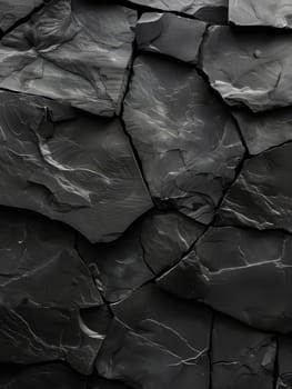 Close-up view of a dark, textured rock surface with jagged and rough texture