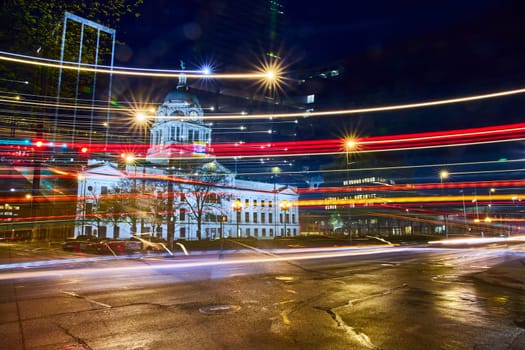 Vibrant night scene at Fort Wayne's historic courthouse, capturing the dynamic blur of city traffic.