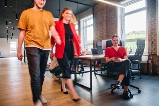 A diverse group of business professionals collaborates in a modern startup coworking center, utilizing a mix of paper-based and technological tools such as mobile phones and computers .