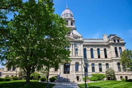 Majestic Kosciusko County Courthouse in Warsaw under a clear blue sky, symbolizing justice and history.