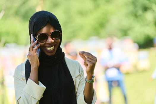 Middle Eastern Muslim woman in a hijab uses a smartphone while managing a small beekeeping business, blending modern technology with traditional practices