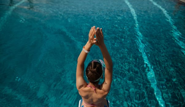 An enchanting woman in swimwear lounges by the pool, with her back to the pool. High quality photo