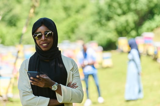 Middle Eastern Muslim woman in a hijab uses a smartphone while managing a small beekeeping business, blending modern technology with traditional practices