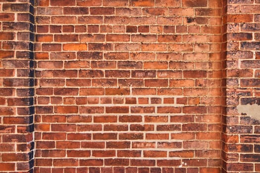 Close-up of a weathered brick wall in Fort Wayne, showcasing the rich texture and warm tones ideal for design and architecture.