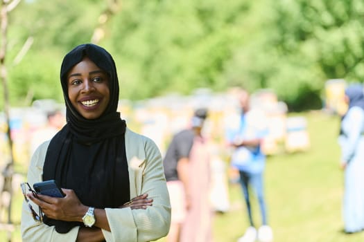 Middle Eastern Muslim woman in a hijab uses a smartphone while managing a small beekeeping business, blending modern technology with traditional practices