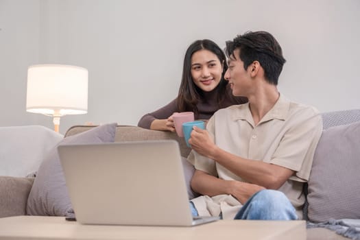 Young Asian couple in love Sitting and relaxing together in the living room happily. Couple making romantic love in the living room.