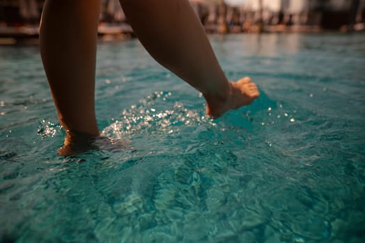 A captivating girl in a bathing suit sits by the pool, her back against the edge. High quality photo