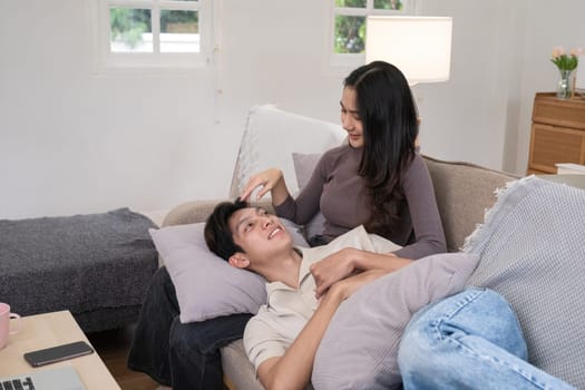 Young Asian couple in love Sitting and relaxing together in the living room happily. Couple making romantic love in the living room.