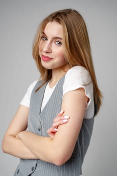 Joyful Young Blonde Woman Smiling against gray background in studio