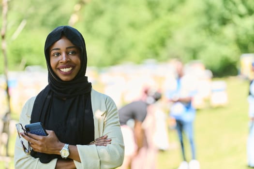 Middle Eastern Muslim woman in a hijab uses a smartphone while managing a small beekeeping business, blending modern technology with traditional practices