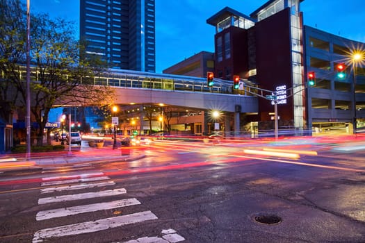 Twilight rush in Fort Wayne: Vibrant light trails weave through bustling downtown streets, capturing urban energy.