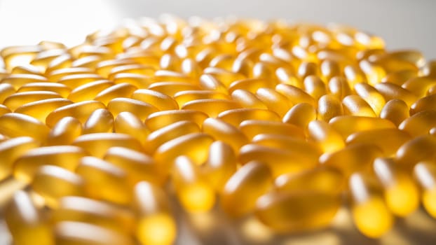 Close-up of golden omega three capsules. Dietary supplement fish oil.