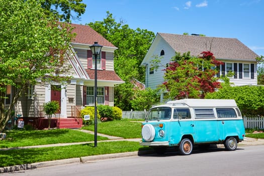 Sunny suburban street with vintage Volkswagen bus and colorful homes in Fort Wayne, Indiana.