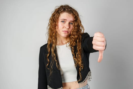 Woman With Curly Hair Giving a Thumbs Down in Studio