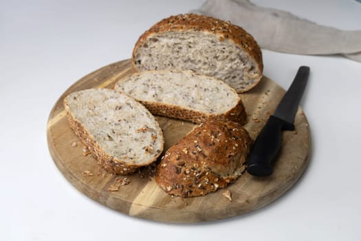 Round freshly oat baked bread sliced on a cutting board. High quality photo