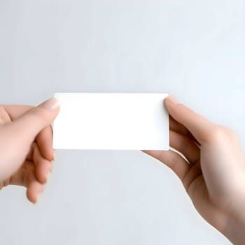 A pair of hands holds a blank white card, waiting to be filled with your creativity and personal touch.