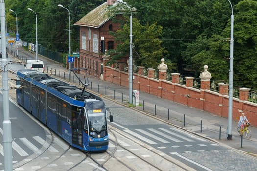 Wroclaw, Poland - August 4, 2023: A blue tram is seen traveling down a bustling city street in Poland.