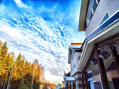 Suburban Street View With Striking Clouds at Dusk. Residential houses under vibrant evening sky with textured clouds