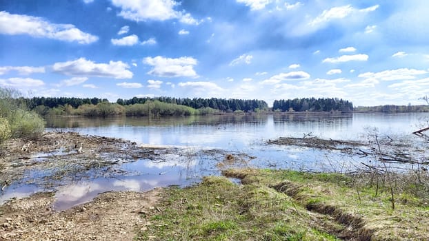 Overflowing river leads to local flooding amidst spring greenery, Springtime Flood Waters Overrunning Riverbanks