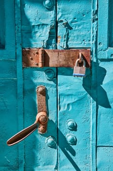 Vivid blue, weathered door with old and new locks in Fort Wayne, symbolizing enduring security and history.