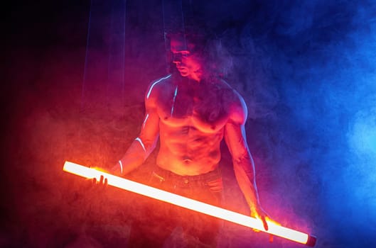 Sporty handsome man with neon light tube under colorful illumination, laser, smoke room. Muscular strong guy with naked torso abs. Projection illusion mapping. Futuristic model.