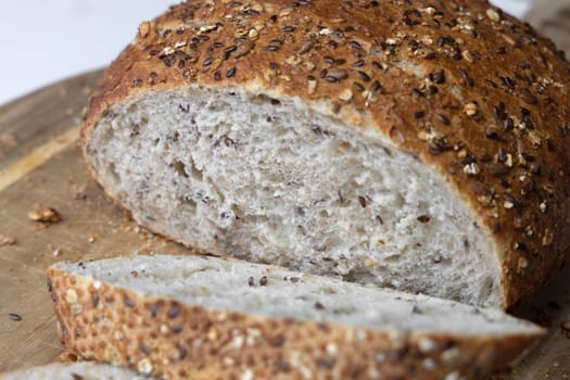 Round freshly oat baked bread sliced on a cutting board. High quality photo