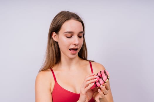 Portrait of beautiful female with chocolate donuts enjoying and looking at the camera