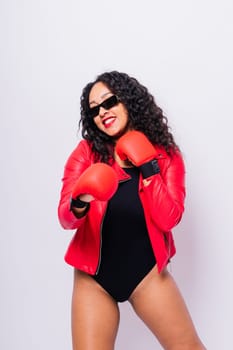 Seductive african woman posing in a black bodysuit and jacket in studio. Fit sporty female.