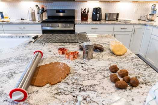 In a contemporary white kitchen, gingerbread cookie dough is skillfully rolled out, setting the stage for a delightful holiday treat.