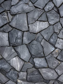 Close-up view of a textured gray slate wall with varied stone sizes and subtle color variations.