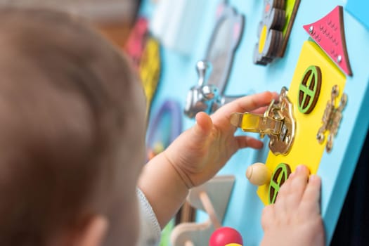 The girl is intently trying to open the lock on the game board.